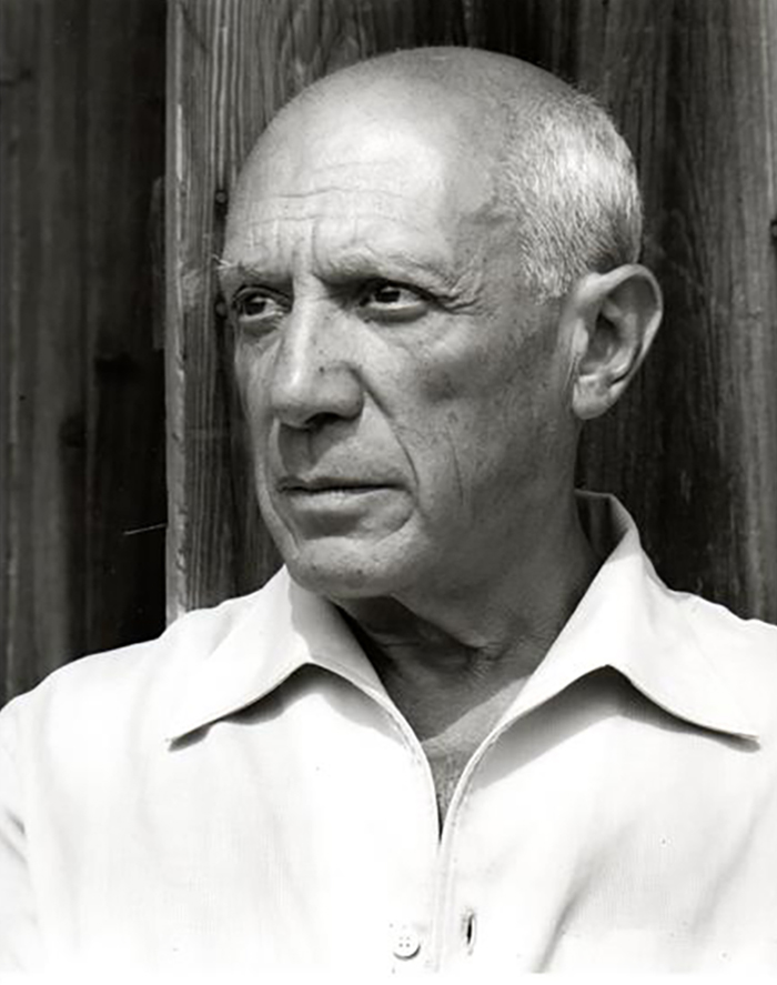 Black-and-white portrait of an older Pablo Picasso in a white shirt, gazing to one side